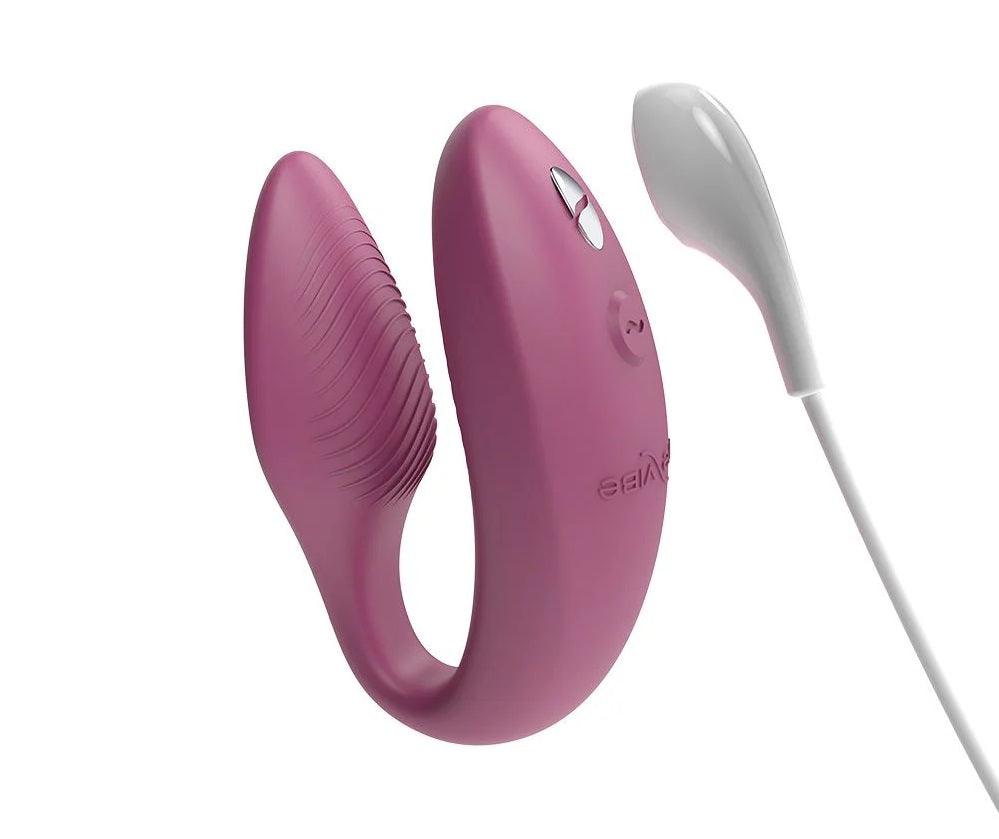 粉紅色We-Vibe Sync 2情侶共用震動器，展示其光滑設計和控制界面，適合親密伴侶使用